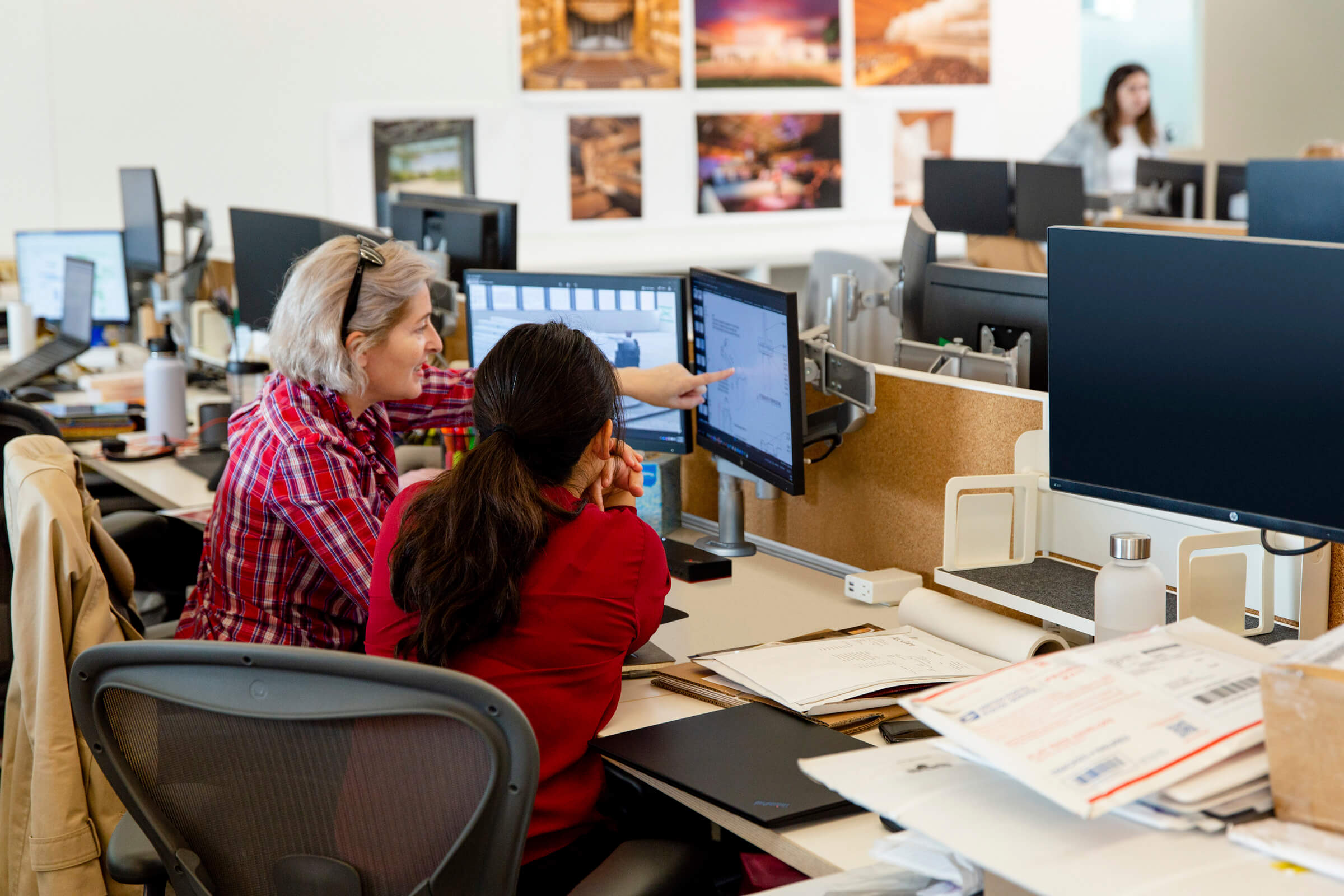 image shows two HGA employees collaborating at their desks