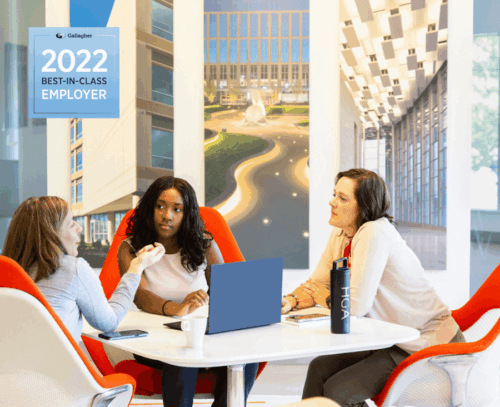 image from HGA DC office, showing 3 employees gathered around a small table in discussion