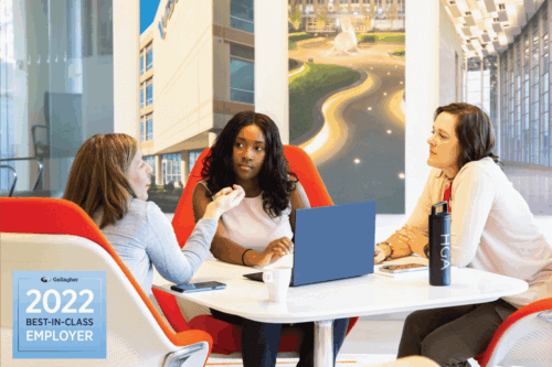 image from HGA DC office, three employees gathered around a small table