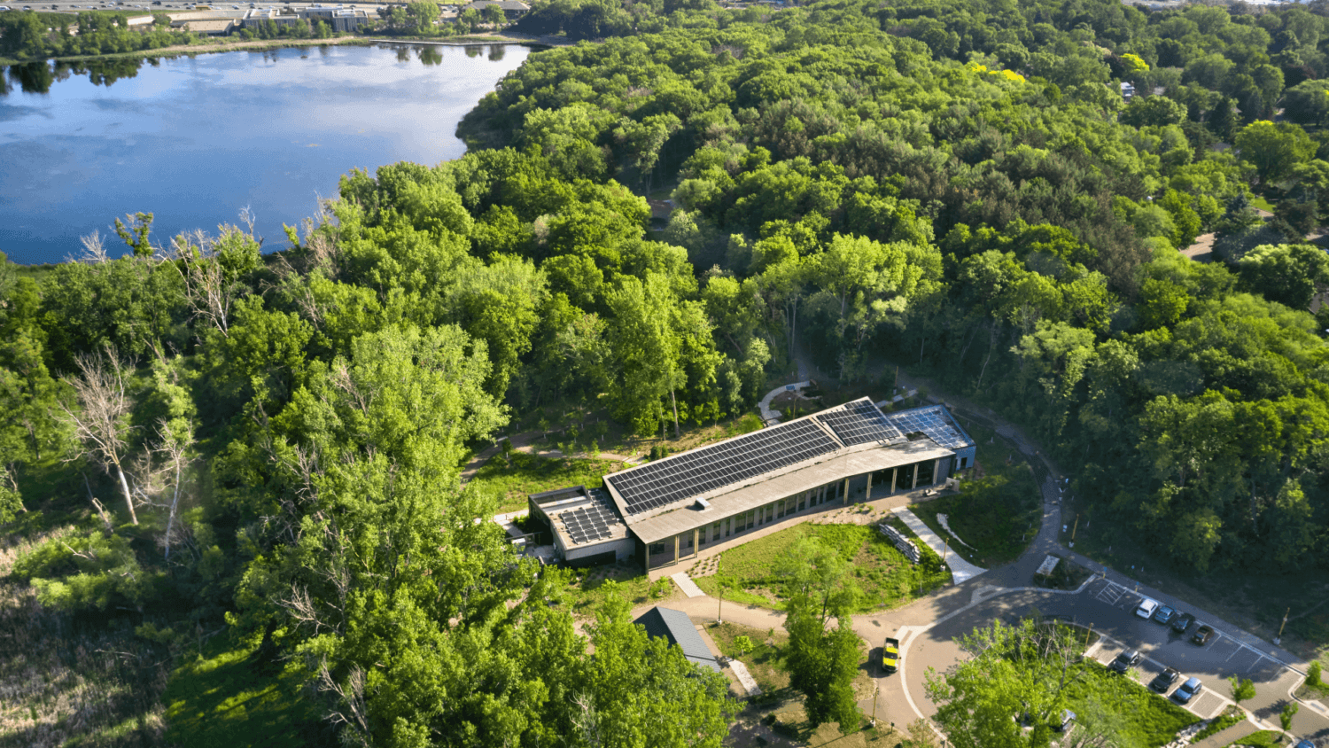 Aerial View of Westwood Hills Nature Center surrounded by trees and a lake
