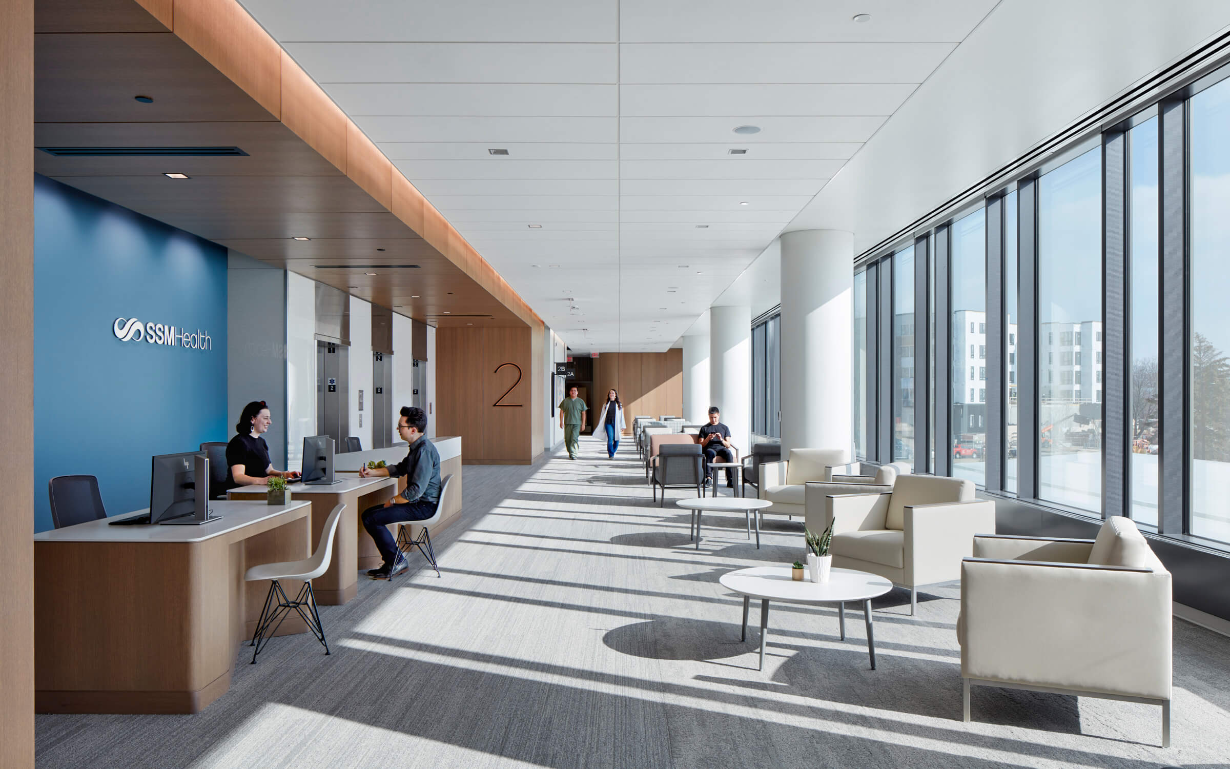 Hospital reception and waiting area with large windows and bright natural light