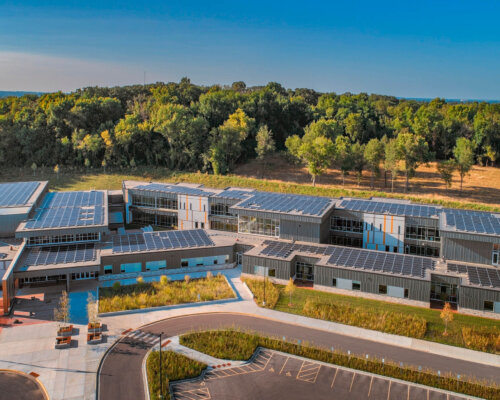 overhead shot of solar panels on forest edge elementary school roof