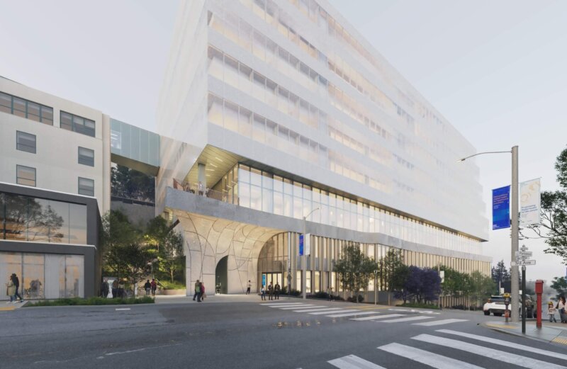 Exterior of a white building with stone accents at a city intersection