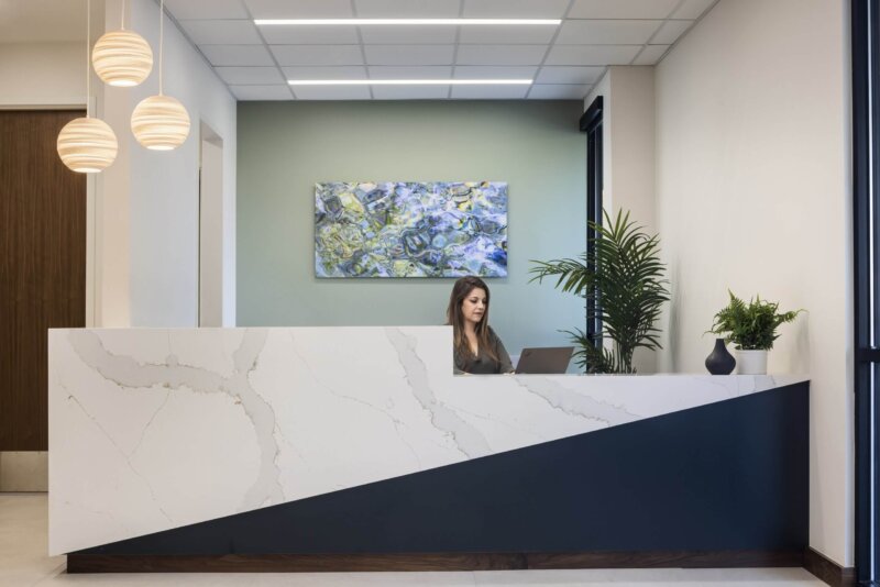Hospital reception desk where a secretary sits at a computer