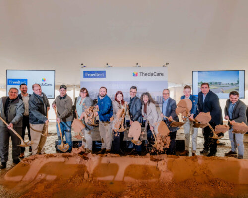 Groundbreaking ceremony with a group of people smiling and holding shovels